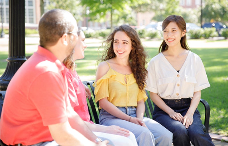 a group of students chat on a bench at the UA quad