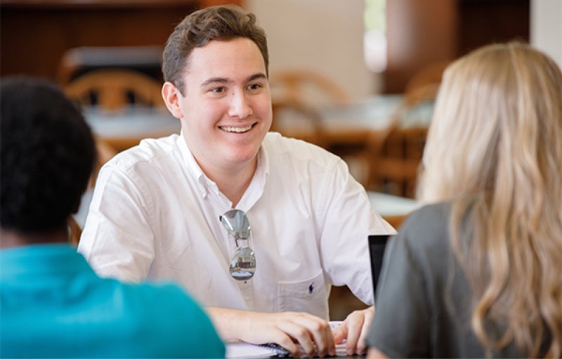 students talk at a table