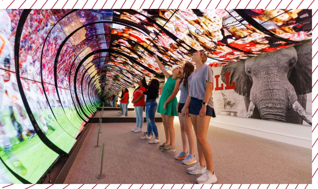 Students watch a video on a large curved screen in the welcome center