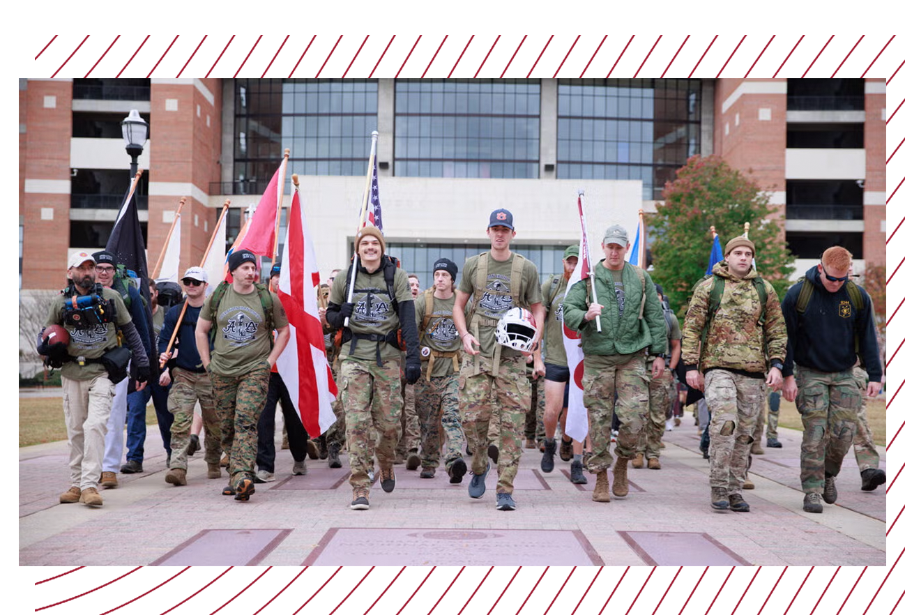 Students dressed in camouflage march together in front of Bryant-Denny Stadium